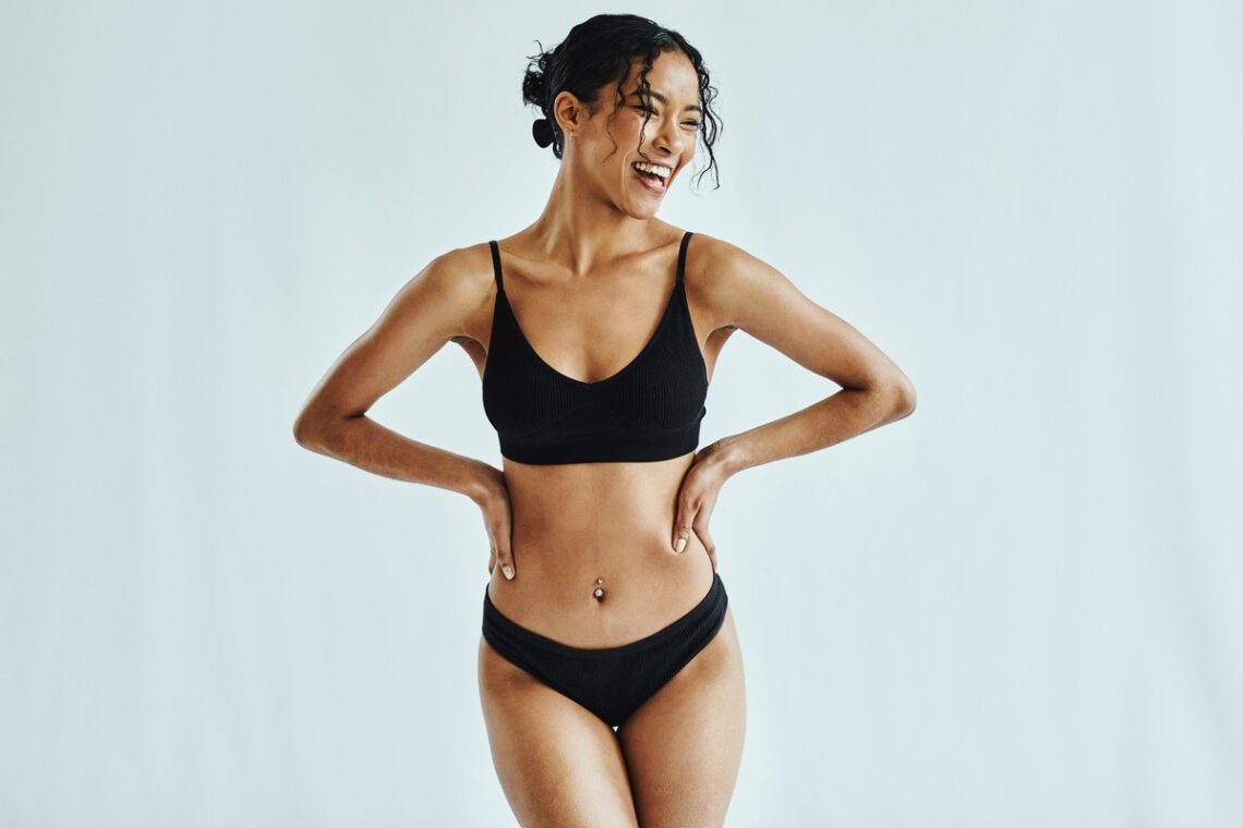 woman smiling happily in underwear breast augmentation recovery