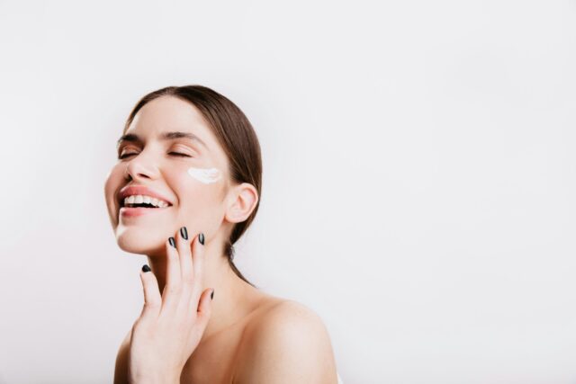 Woman with glowing skin applying hyaluronic acid